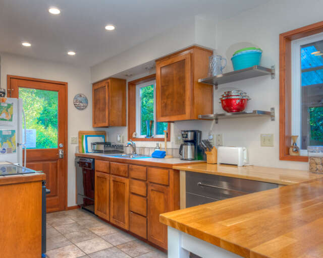 Fully equipped kitchen with access out to back deck with hot tub and outdoor dining area. Fully equipped kitchen with access out to back deck with hot tub and outdoor dining area.