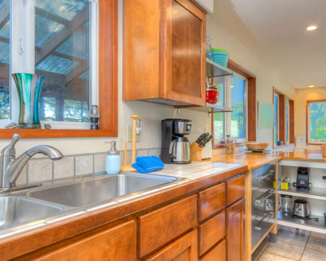 Fully equipped kitchen with access out to back deck with hot tub and outdoor dining area. Fully equipped kitchen with access out to back deck with hot tub and outdoor dining area.