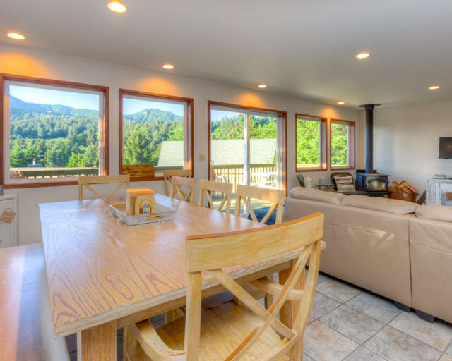 Dining/ Living room with TV, wood fireplace and access to deck with mountain view.  Dining/ Living room with TV, wood fireplace and access to deck with mountain view.