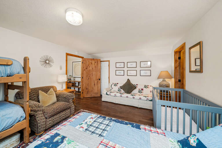 Bunk room with cozy couch, set of bunks, 2 twin beds, and crib.  Bunk room with cozy couch, set of bunks, 2 twin beds, and crib.