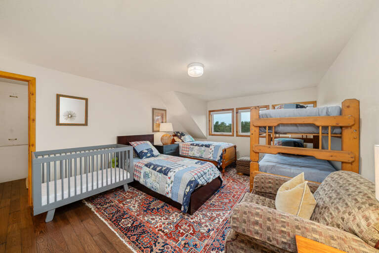 Bunk room with cozy couch, set of bunks, 2 twin beds, and crib.  Bunk room with cozy couch, set of bunks, 2 twin beds, and crib.