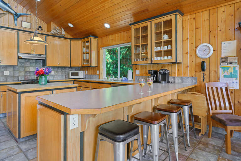 Upstairs fully stocked kitchen with island and breakfast bar, open to  living room with Cable TV, gas fireplace, 2 sleeper sofas and dining area. Access to front deck with BBQ. 
