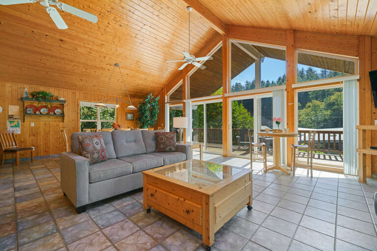 Upstairs open living space with Cable TV, gas fireplace, 2 sleeper sofas, fully stocked kitchen, and dining area. Access to front deck with BBQ. 