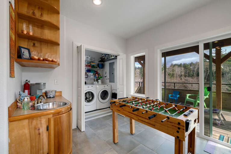 Lower living area with books, games, streaming TV, movies, foos ball table and access to lower deck. Wet bar with Keurig coffee station. Laundry room with loaner golf clubs, beach towels, beach chairs.  Lower living area with books, games, streaming TV, movies, foos ball table and access to lower deck. Wet bar with Keurig coffee station. Laundry room with loaner golf clubs, beach towels, beach chairs.