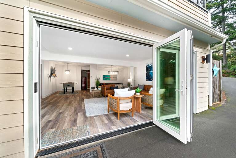 Newly remodeled family room with panoramic doors that open fully. With drink fridge, Foos ball, Air hockey, Smart TV, electric fireplace, and comfy lounge area. 