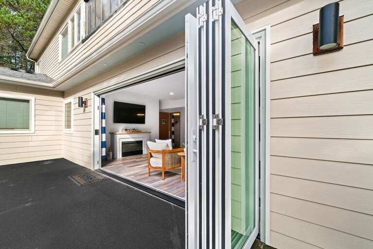 Newly remodeled family room with panoramic doors that open fully. With drink fridge, Foos ball, Air hockey, Smart TV, electric fireplace, and comfy lounge area. 