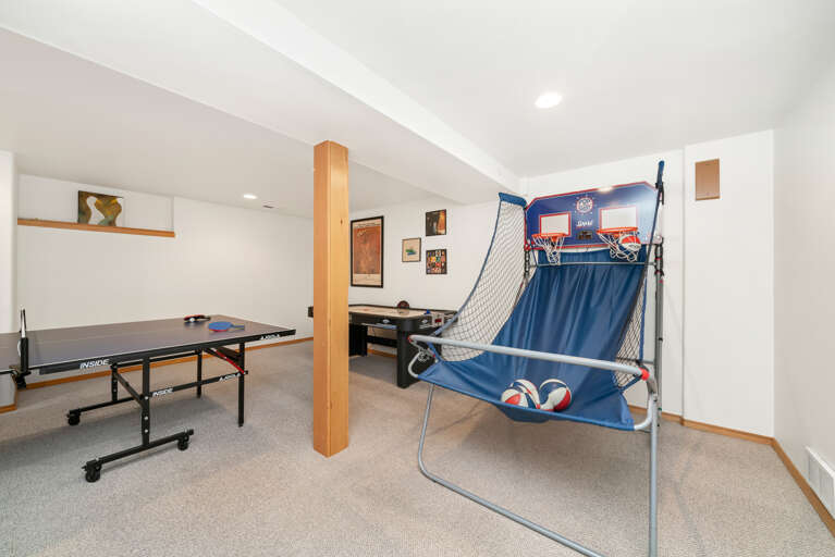 Downstairs game room with Ping pong table, Basketball game, Air Hockey, foos ball, and Large sectional couch, and mini fridge. 