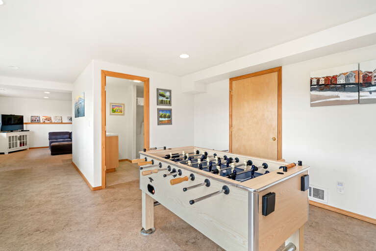 Downstairs game room with Ping pong table, Basketball game, Air Hockey, foos ball, and Large sectional couch, and mini fridge. 