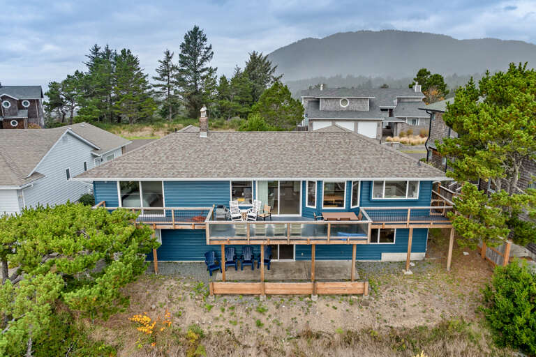 Large deck with outdoor dining tables, Gas BBQ, and chairs. 