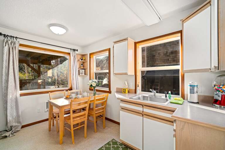 Downstairs small game/dining table in the kitchenette area (no appliances) with sink and gumball machine. 