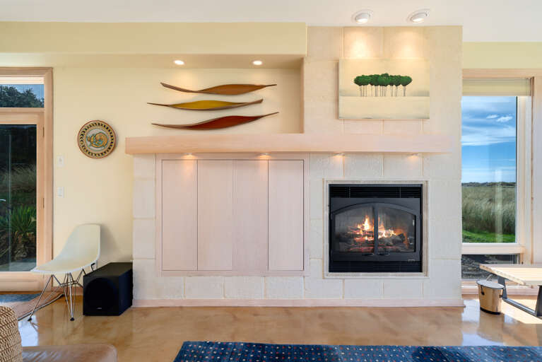 Living room with gas fireplace, Direct TV, Ocean views, Surround sound, Overhead fans, open to dining area.