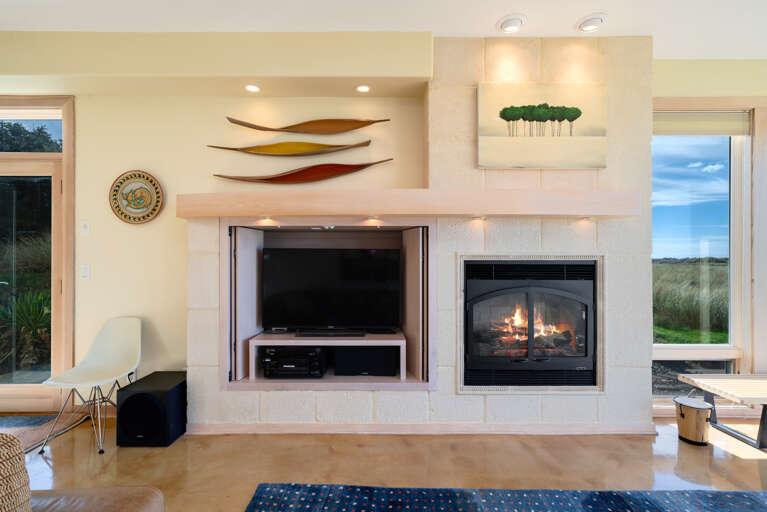 Living room with gas fireplace, Direct TV, Ocean views, Surround sound, Overhead fans, open to dining area.