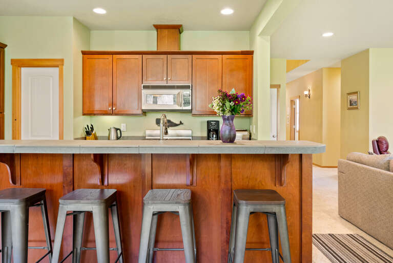 Fully equipped kitchen open to the dining room and living room with fireplace, TV, large cozy couch, access to back yard with firepit.