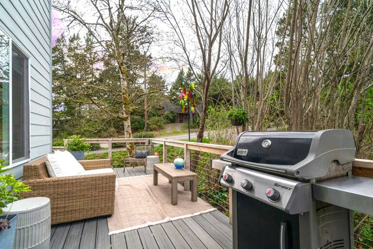 Hot tub on the back deck, with outdoor dining, lounge furniture, Gas BBQ, and fenced in area. 