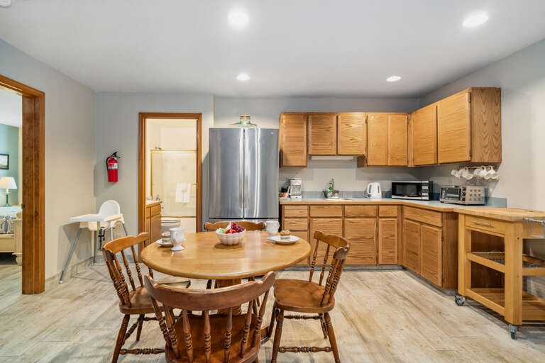 Downstairs family room with streaming TV, Kitchen/dining area with kitchenette with High chair, Access to garage with foosball, faux ax throwing, and darts. 