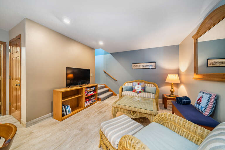 Downstairs family room with streaming TV, Kitchen/dining area with kitchenette with High chair, Access to garage with foosball, faux ax throwing, and darts. 