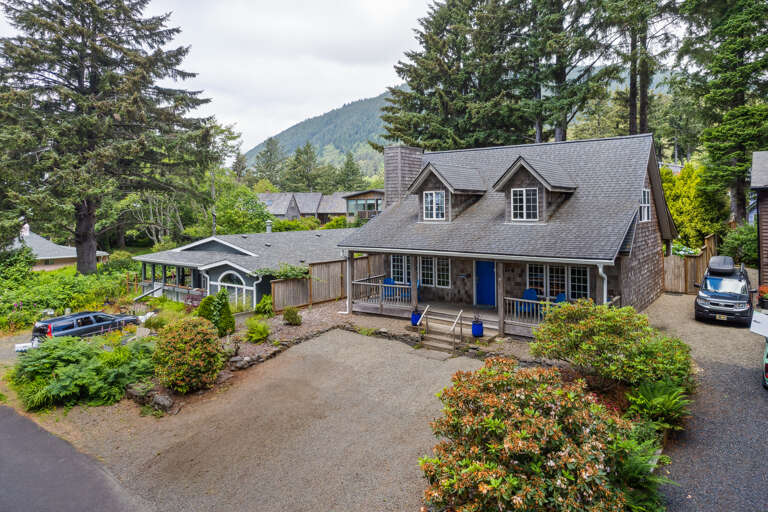 Street view with front covered porch with Adirondack chairs for relaxing in. 