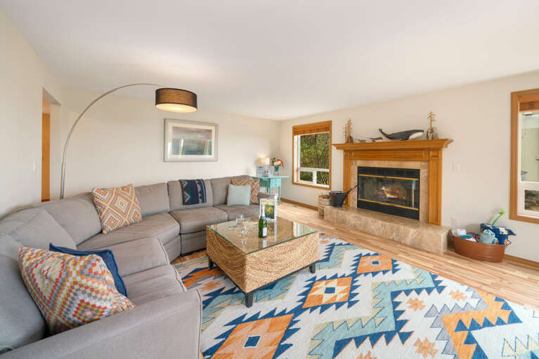 Main floor living room with fireplace, ocean view, Roku w/live TV, DVD player, books, games. 