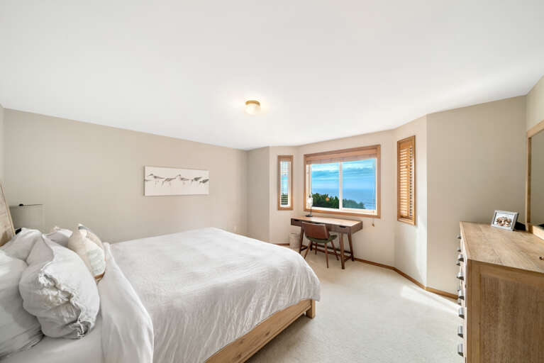 Upstairs King bedroom with ocean view and workspace desk. 