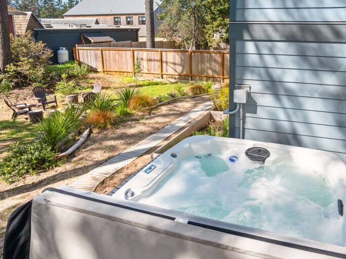Back yard area with hot tub and outdoor firepit. 
