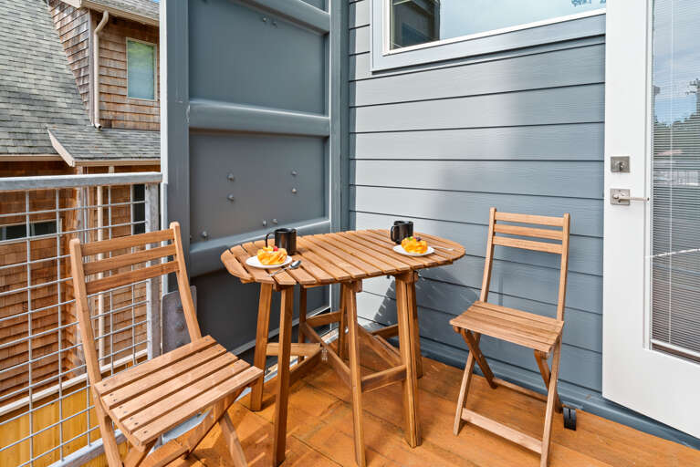 Upper deck that overlooks the back yard with breakfast table, electric BBQ.