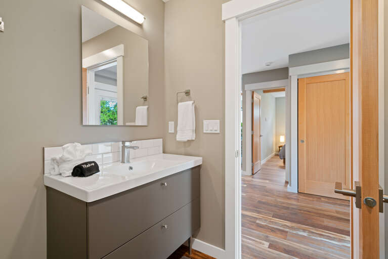 Main floor full bath with walk in shower and stackable washer/dryer.