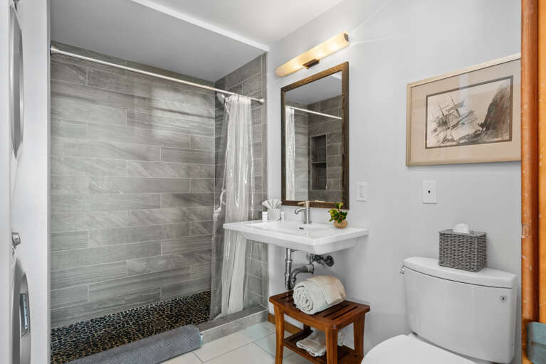 Downstairs full bath with walk in shower with stackable washer/dryer