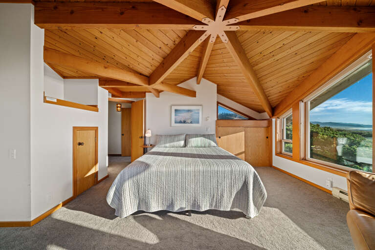 Master bedroom with expansive views, working desk and lounge chair. 
