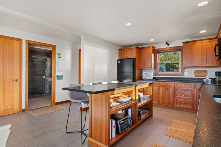 Gourmet Kitchen with breakfast bar open to living area, dining area, and with ocean views