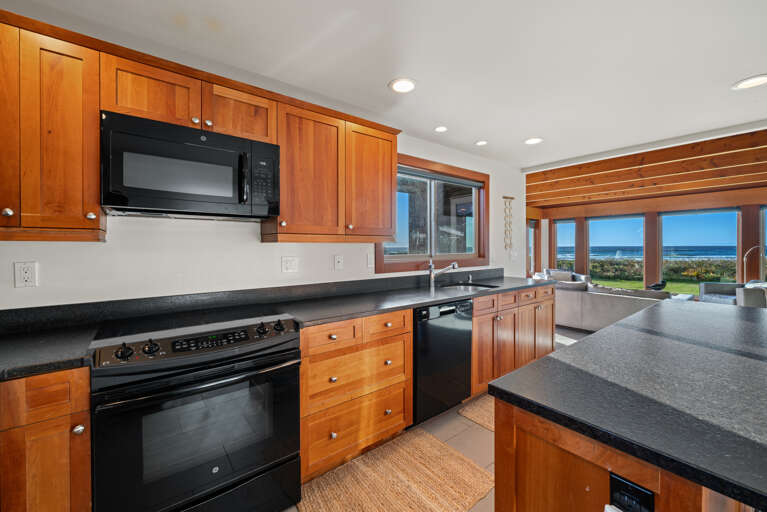 Gourmet Kitchen with breakfast bar open to living area, dining area, and with ocean views