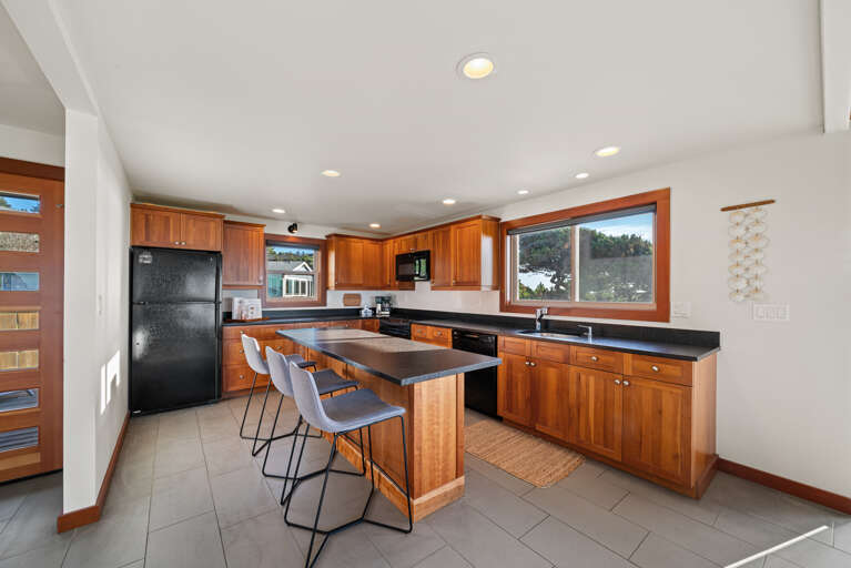 Gourmet Kitchen with breakfast bar open to living area, dining area, and with ocean views