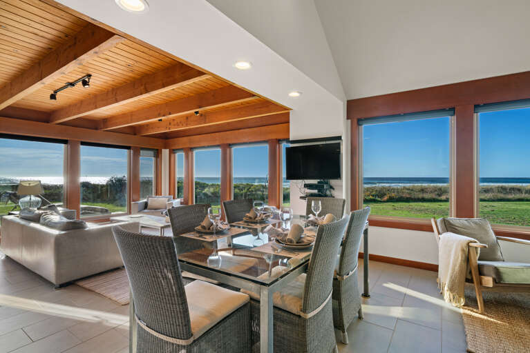 Open living area with smart TV, dining and kitchen area with ocean views.