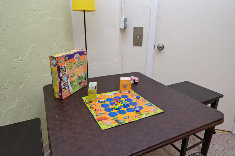 TV room off of the garage with Futon, card table, and Roku TV. 