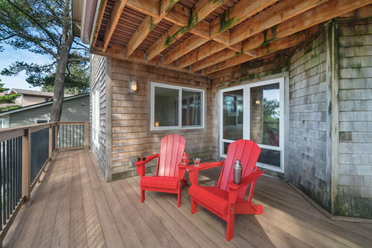 Lower deck with shaded area and Adirondack chairs.