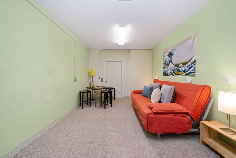 TV room off of the garage with Futon, card table, and Roku TV. 