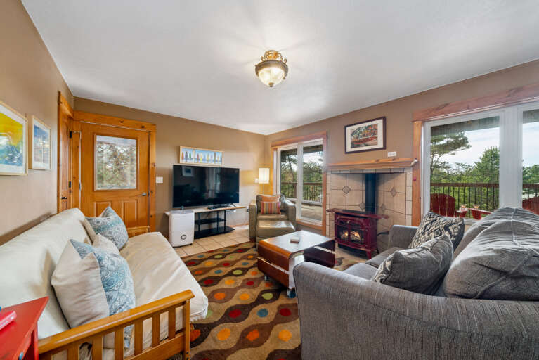 Middle floor living space with big screen tv, gas fireplace, and access to lower deck. 