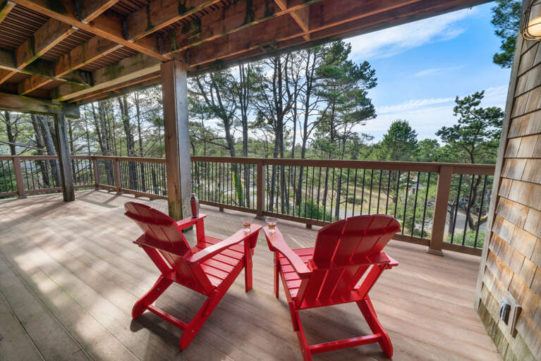 Lower deck with shaded area and Adirondack chairs.