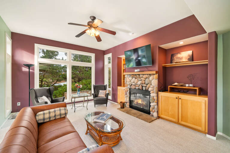 Living room with Smart TV, Wood burning fireplace, and golf course view.
