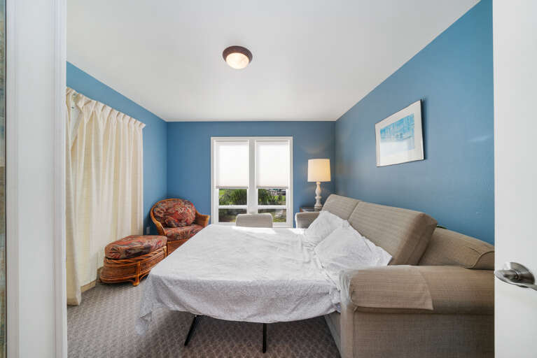 Den with golf course view, desk workspace, Queen sofa sleeper, and lounge chair. 