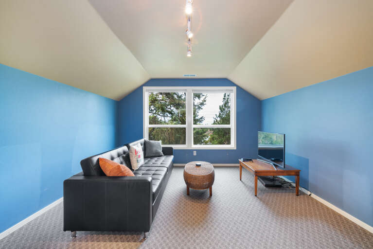 Upstairs bedroom with Euro double sleeper, DVD TV, wet bar, mini fridge, golf course view, and peak ocean view. 