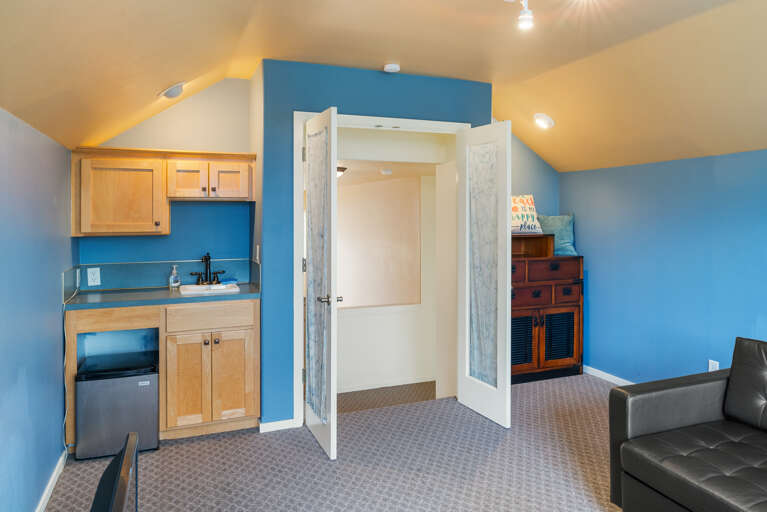 Upstairs bedroom with Euro double sleeper, DVD TV, wet bar, mini fridge, golf course view, and peak ocean view. 