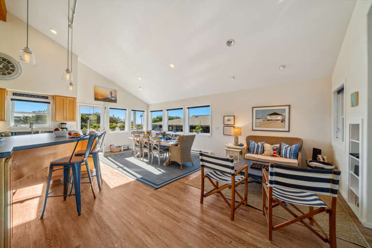 Dining table open to kitchen with breakfast bar and access to deck with ocean view