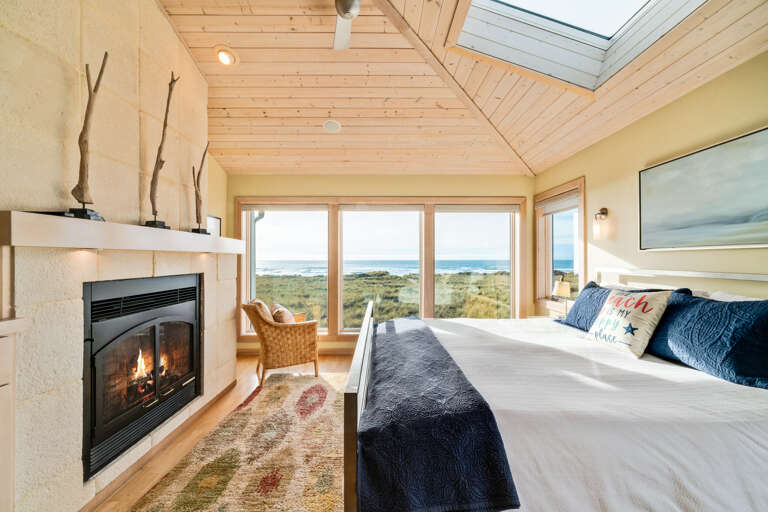 Master bedroom with ocean view, desk work space, gas fireplace, king bed, sitting chair, and TV with Direct TV and streaming.  Master bedroom with ocean view, desk work space, gas fireplace, king bed, sitting chair, and TV with Direct TV and streaming.