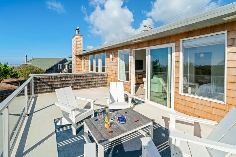 Master bedroom deck with wind block glass panels. 