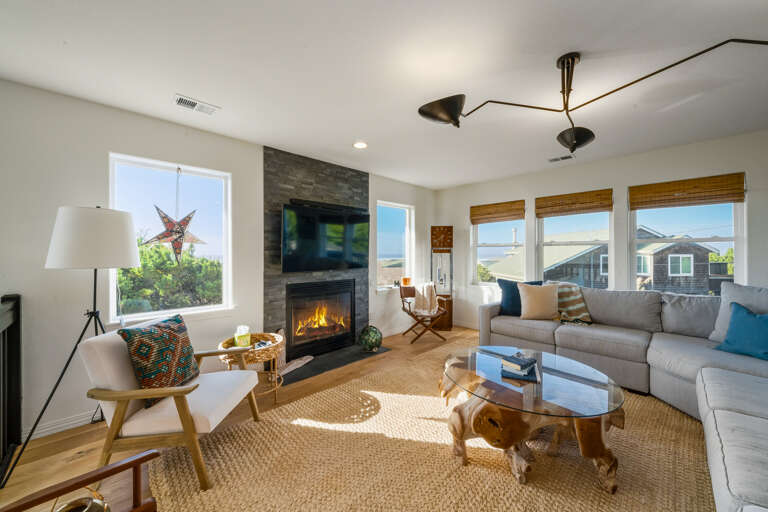Comfy living room with gas fireplace, Ocean view,  and streaming TV. Open to the kitchen and dining room. 