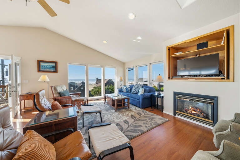 Open living area that includes the living area with gas fireplace, sleeper sofa, streaming tv, comfortable chairs and ocean views.