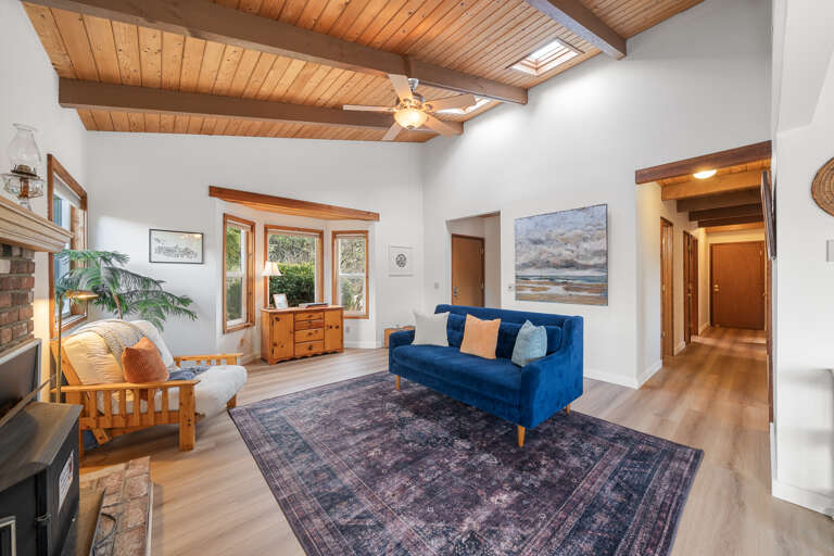 Open living area with dining room and access to the front and back decks. Note: The woodstove is NOT operational