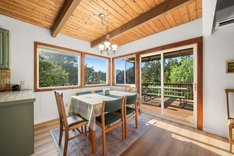 Dining area with access to deck with BBQ and outdoor seating. 