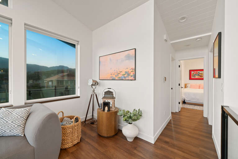 Living room with streaming TV, ocean view, and comfortable seating. Hallway to the bedrooms and baths. 