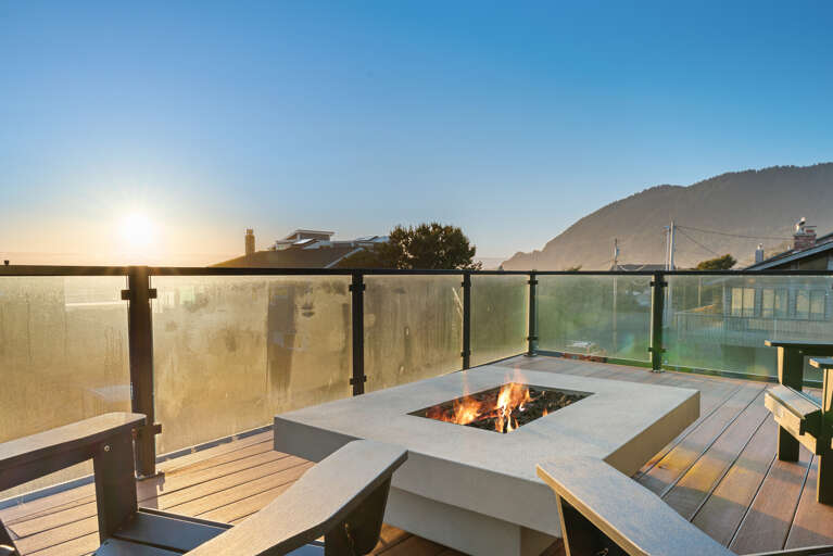 Outdoor fire table with ocean and mountain views.